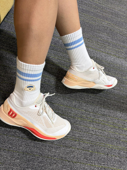 Pupcourt crew socks with the embroidered golden retriever, worn with tennis shoes
